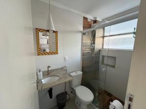 a white bathroom with a toilet and a sink at STUDIO MANDARIM EM FRENTE A PRAIA DO GONZAGA in Santos