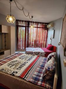 a bedroom with a large bed and a window at Студио Релакс, Ахелой in Aheloy