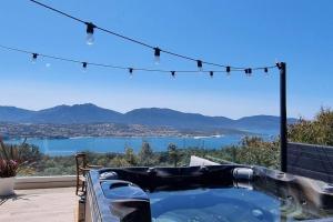 patio con vasca idromassaggio e vista sull'acqua di Maison avec jacuzzi a Olmeto