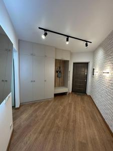 an empty room with wood floors and a brick wall at Apartamenty Stepana Bandery 35 in Truskavets