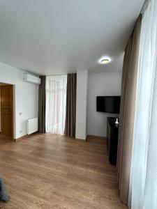 a living room with a flat screen tv and a large window at Apartamenty Stepana Bandery 35 in Truskavets