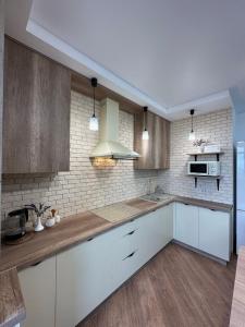 a kitchen with white cabinets and a counter top at Apartamenty Stepana Bandery 35 in Truskavets