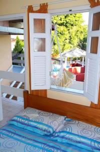 a room with a window with a hammock outside at Porto Verano Residence in Porto Seguro