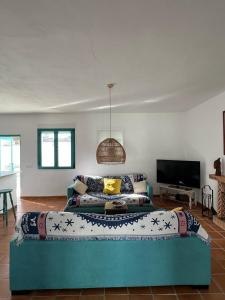 ein Wohnzimmer mit einem Sofa und einem TV in der Unterkunft Villa Turquesa in Zahora