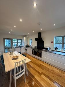 a kitchen with a wooden table and a table and chairs at BROOK HOUSE 4a in Llangollen