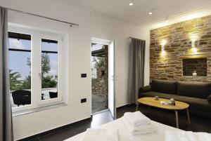 una sala de estar con un sofá y una mesa en White and black Suites Triple, en Sifnos