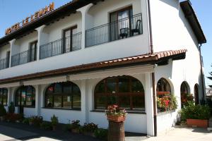 a white building with windows and balconies on it at Motel Le Léman in Commugny