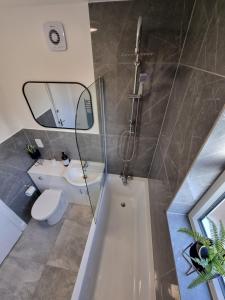 a bathroom with a toilet and a sink and a mirror at Cute Cottage in Egham Heathrow- 7 Guests 3 bedrooms in Egham