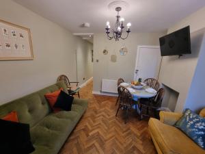 a living room with a couch and a table at Cute Cottage in Egham Heathrow- 7 Guests 3 bedrooms in Egham