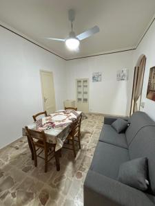 ein Wohnzimmer mit einem Sofa und einem Tisch in der Unterkunft November House Cefalù in Cefalú