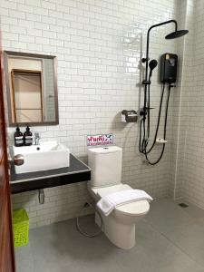 a bathroom with a toilet and a sink at บ้านกานดา in Seka