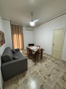 ein Wohnzimmer mit einem Sofa und einem Tisch in der Unterkunft November House Cefalù in Cefalú