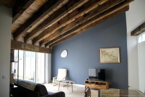 ein Wohnzimmer mit blauen Wänden und Holzbalken in der Unterkunft Le vieux chai in Sainte-Marie-de-Ré