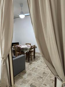 ein Esszimmer mit einem Tisch und einem Vorhang in der Unterkunft November House Cefalù in Cefalú