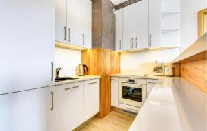 a kitchen with white cabinets and white appliances at 2 Bedroom Gorgeous Apartment In Hel in Hel