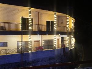 a building with lights on the side of it at night at Al Sadiq Guest House in Murree