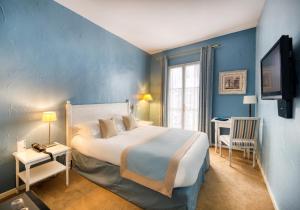 una camera con un grande letto e una parete blu di Hotel d'Aragon a Montpellier