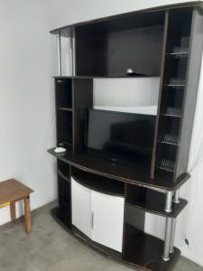 een zwart entertainmentcentrum met een flatscreen-tv bij Kitnet em Matinhos PR in Matinhos
