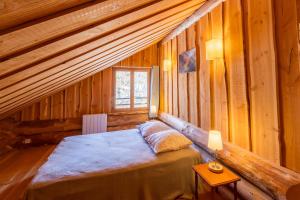 - une chambre avec un lit dans une cabane en bois dans l'établissement Chalet l'Epicurien - Au calme avec grand jardin, à Saint-Martin-du-Puy