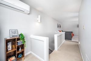 an attic hallway with white walls and a white door at Retro Loft steps from Duke in Durham