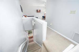 a staircase in a house with white walls and white floors at Retro Loft steps from Duke in Durham