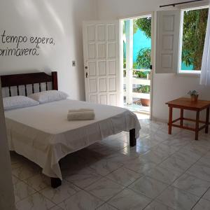 a bedroom with a large bed and a table at Pousada Iakã Boipeba in Cayru