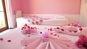 ein rosafarbenes Zimmer mit einem Bett und Schuhen auf dem Boden in der Unterkunft İdavilla Bungalov & Bahçe in Akçay