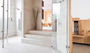 un bagno con una porta a vetri che conduce a una scala di Living Hotel Weißensee a Berlino Altre 33 foto