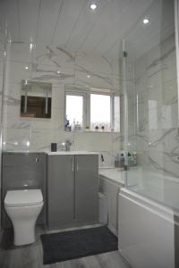 La salle de bains blanche est pourvue de toilettes et d'un lavabo. dans l'établissement Quiet Enclave on the marina, Free Parking, à Hull