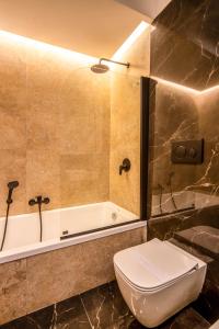 a bathroom with a toilet and a bath tub at Arthouse Lady Marys Tribunali Luxury Suite in Naples
