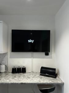 a flat screen tv hanging on a wall at Town Centre Studio Flat in Merthyr Tydfil