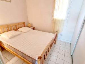 een slaapkamer met een bed in een kamer met een raam bij Appartement Six-Fours-les-Plages, 2 pièces, 4 personnes - FR-1-316-96 in Six-Fours-les-Plages