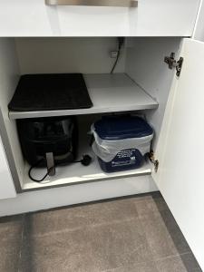 uma gaveta num armário com um contentor dentro em Town Centre Studio Flat em Merthyr Tydfil