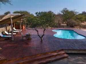 una terrazza con piscina, tavolo e sedie di Evolve Back Kalahari a Central Kalahari