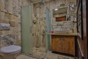 a stone bathroom with a toilet and a sink at Feel Cappadocia Stone House in Goreme