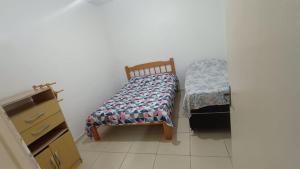 a small bedroom with a bed and a dresser at Casa de Praia Extremo Sul in Rio Grande