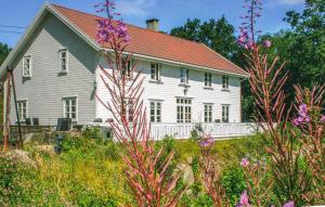 法爾松的住宿－Lovely Home In Farsund With Wi-fi，白色的房子,有红色的屋顶和一些花