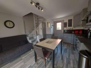 uma cozinha e sala de estar com uma mesa e um sofá em Maison Marseillan-Plage, 3 pièces, 6 personnes - FR-1-326-693 em Marseillan