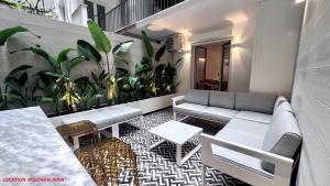 a patio with a couch and a table and some plants at PINACOTA SUITES ATHENS in Athens