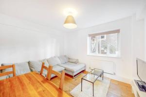 - un salon avec un canapé et une table dans l'établissement Cozy 3 bedroom apartment in Brixton, à Londres