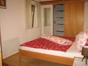 a small bedroom with a bed with a red pillow at Appartement Hoch Kranachberg in Gamlitz