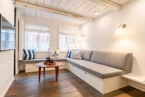uma sala de estar com um sofá e uma mesa em Der kleine Carl em Wyk auf Föhr