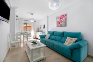 Apartamento Altamar في نوفو سانكتي بيتري: غرفة معيشة مع أريكة زرقاء وطاولة