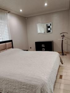 a bedroom with a white bed and a mirror at Apartment at Kvitka Polonyny in Solochin