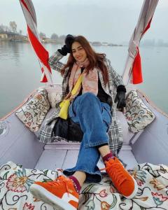 a woman sitting on the back of a boat at Pasadona Floating Houseboat in Srinagar