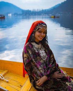 una mujer sentada en un barco en el agua en Pasadona Floating Houseboat, en Srinagar