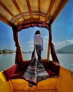 a woman standing in the back of a boat at Pasadona Floating Houseboat in Srinagar