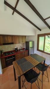 a kitchen with a wooden table and chairs at Cabañas Nazak Lago 1 in Pereira