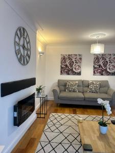 a living room with a couch and a clock on the wall at BROOK HOUSE 4a in Llangollen +53 photos