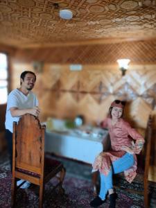 a man and a woman sitting in a room at Pasadona Floating Houseboat in Srinagar